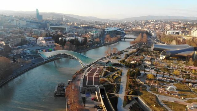 4k aerial view modern infrastructure soft morning light skyline bridge over the river. Tbilisi, Georgia. Rike Park