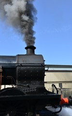 Obraz na płótnie Canvas A black steam engine at a station.