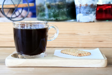 Cup of espresso coffee  with cracker cookies on wooden plate in morning time.