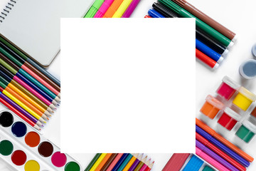 Creative flat lay back to school concept with colored pencils, gouache, watercolor, plasticine and notepad on white background. Flat lay, top view, copy space.