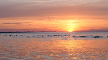 Fototapeta na wymiar Beautiful fiery sunset sky on the beach. Composition of nature, Waves of the sea on a sandy beach.