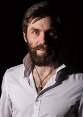 Portrait handsome bearded man, sexy guy on a dark background