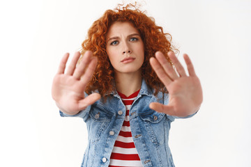 No you must stop. Serious-looking displeased ginger girl 25s curly hairstyle extend palms forward...