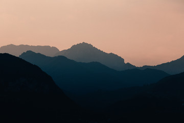 Natural patterns: layers of mountains in a foggy soft light at sunset. Garda Lake, Italy. Artistic, almost abstract