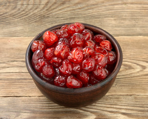 Bowl with tasty cherries on wooden background.