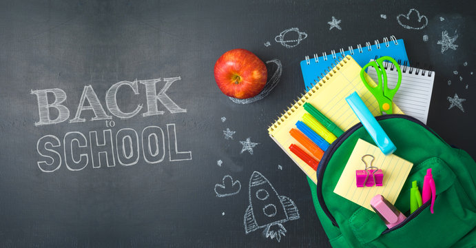 Back to school concept with bag backpack and school supplies over chalkboard background.