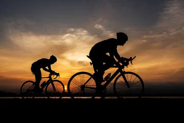 Tuinposter Silhouette two road bike cyclist man cycling in the morning. © ibravery