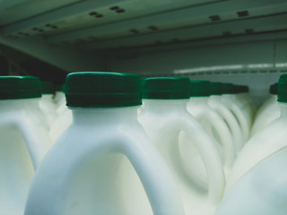 Milk in plastic bottles with green lids, close-up in a store.