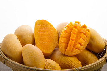 Sliced and Half cut of Ripe mango tropical fruit in wooden basket and white background, metaphor Thai dessert Mango sticky rice