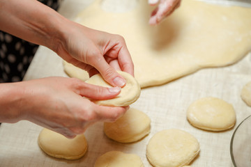 Making dough for cherry pies in the home kitchen. Female hands stir the dough.