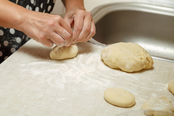 Cooking cherry pies in the home kitchen. Women's hands in the process of cooking cakes with cherries.