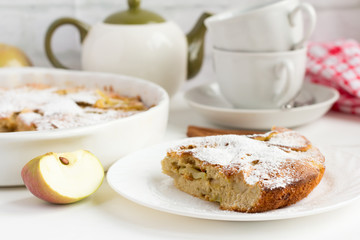 traditional homemade Apple pie with cinnamon and tea utensils on the table