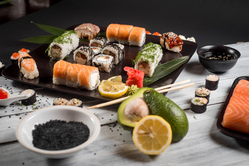 Sushi set with salmon, eel, tuna, avocado, cream cheese Philadelphia, caviar, chuka. Sushi menu. Japanese food on black and white background
