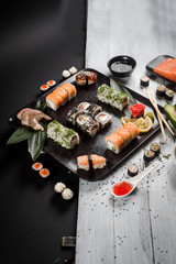 Sushi set with salmon, eel, tuna, avocado, cream cheese Philadelphia, caviar, chuka. Sushi menu. Japanese food on black and white background