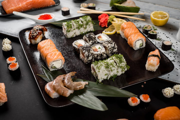 Sushi set with salmon, eel, tuna, avocado, cream cheese Philadelphia, caviar, chuka. Sushi menu. Japanese food on black and white background