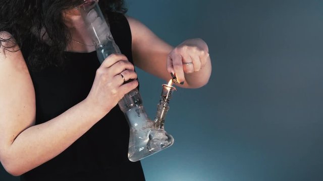 The person smoking marijuana with bong, close-up. Bong in the female hand. Cannabis is medicine 