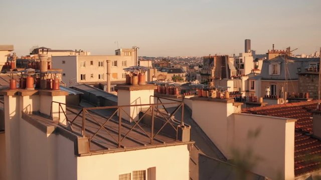 Panoramic view on parisian rooftops and Eiffel tower in Paris from the balcony on warm summer evening