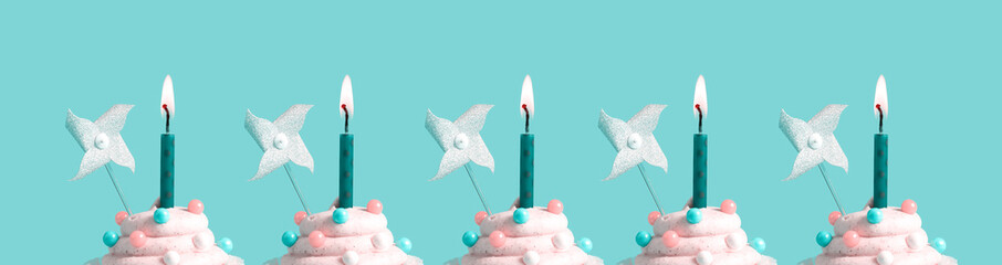 Tasty celebratory cupcakes with decorative lit candles