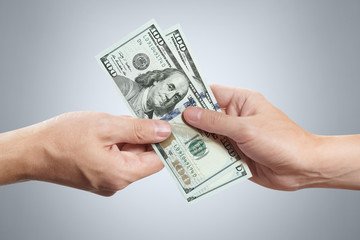 Hands sharing dollars on gray background