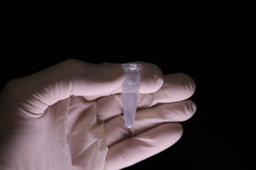 White gloved hand with test tube