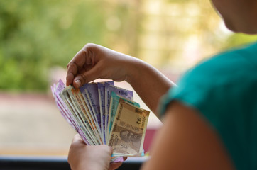An Indian women holding all the colorful new released Indian Rupees currency notes in her hands after demonetisation in denominations 10,50,100, 200, 500, 2000 in her hands