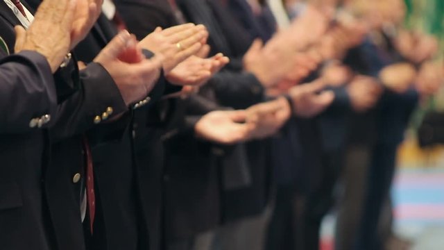 Business people standing in the row at the conference - clapping their hands