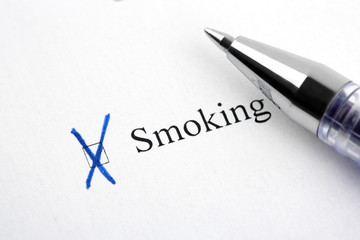 Fototapeta premium Smoking. Filling in the questionnaire, documents. The checkboxes are filled with a black pen on a white background. Questionnaire, survey.