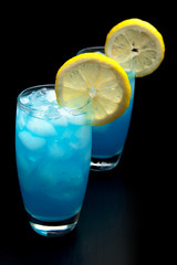 Blue lagoon cocktails with slice of citrus isolated on black