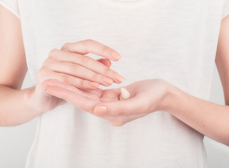 Spa treatment. Close Up of female hands applying hand cream. Woman holding cream tube and applying moisturizer cream on her beautiful hands for clean and soft skin.