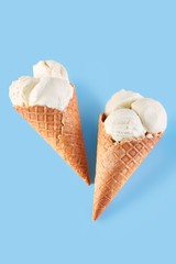 ice cream balls in a Waffle Cone on a Blue Background. Vanilla ice cream in a waffle cone.
