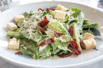 Close up organic caecar salad in white dish. International food