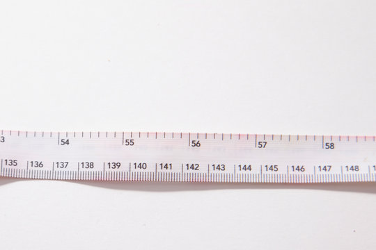 White measuring tape against a white background
