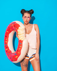 Young beautiful sexy smiling hipster woman in sunglasses.Girl in summer clothes with donut lilo...