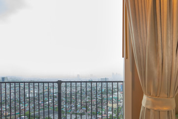 The atmosphere of the city, looking from the window with curtains, balcony, condo