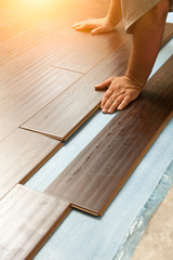 Fototapeta na wymiar Man Installing New Laminate Wood Flooring