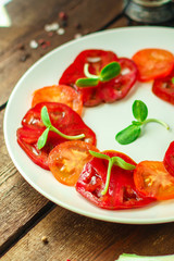 tomatoes salad with sunflower seedlings microgreen (carpaccio, sliced ​​raw vegetables). food background. top view. copy space