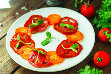 tomatoes salad with sunflower seedlings microgreen (carpaccio, sliced ​​raw vegetables). food background. top view. copy space