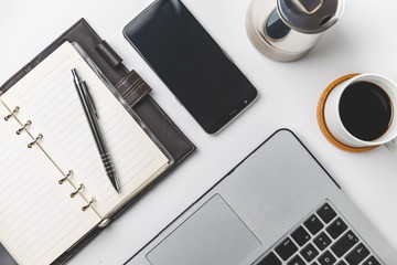close up of smartphone, laptop, note and coffee cup . business and workplace concept . isolated freelancer tools