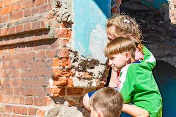 Three children in a destroyed house are hiding from military conflicts, refugee children have...