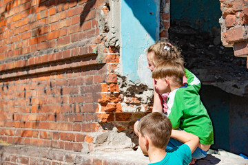 Three children in a destroyed house are hiding from military conflicts, refugee children have...