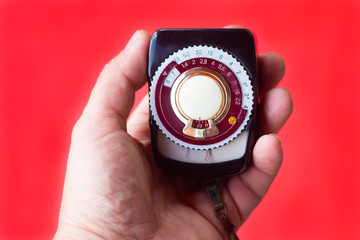 old vintage Soviet exposure meter with leather case on red background