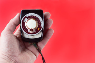 old vintage Soviet exposure meter with leather case on red background