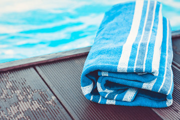 blue towel near swimming pool, tropical background.