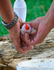 Fishing - preparing tackle for feeding fish. Hands fill the feeder for fishing different fish species. Healthy lifestyle consept