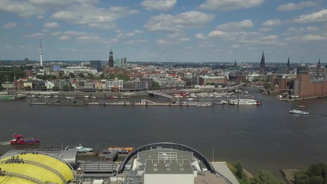 Scenic panorama over the Hamburg Harbor with Landungsbruecken, musical halls, ships and boats on river Elbe towards the new Elbphilharmonie