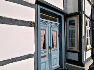 Restauriertes Fachwerkhaus mit schöner verzierter alter blaugrauer Haustür mit gemusterten...