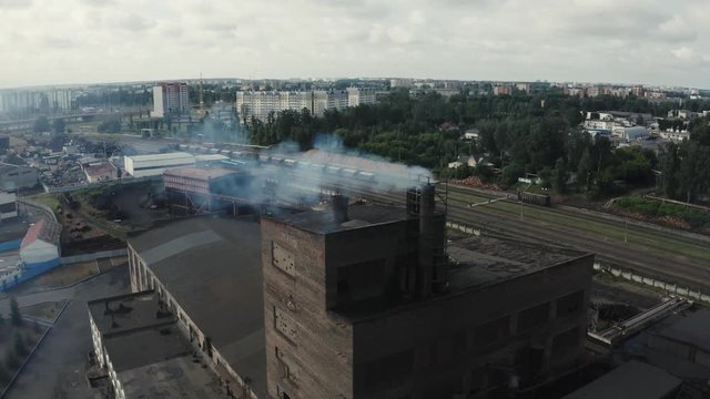 Industrial zone with smoke is poured from the factory pipe. Pollution of the environment: a pipe with smoke. Aerial view