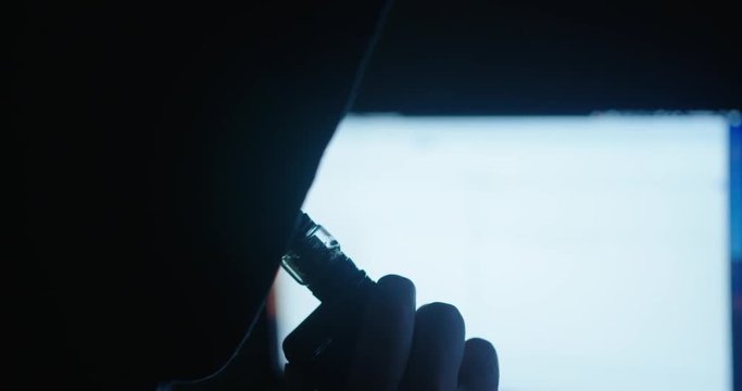 Close Up Hooded Man Vaping And Blowing Smoke Indoors In Slow Motion