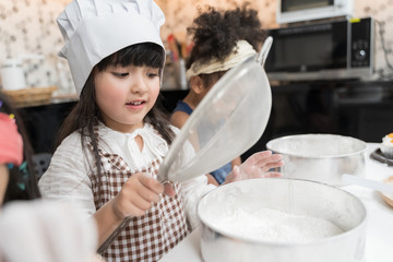 Group of kids are preparing the bakery in the kitchen .Children learning to cooking cookies