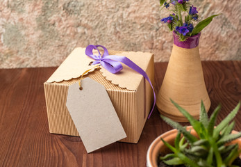 Vintage gift box of micro corrugation on a wooden table with a tag from kraft cardboard for text....